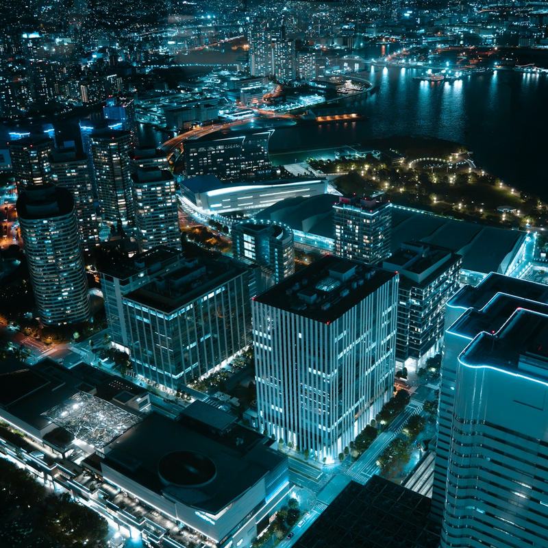 Vista aérea noturna de uma cidade iluminada, com dados e infraestrutura urbana em operacao.