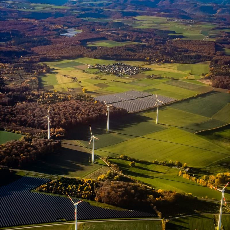 Paisagem rural com aerogeradores e campos cultivados, vista aerea.